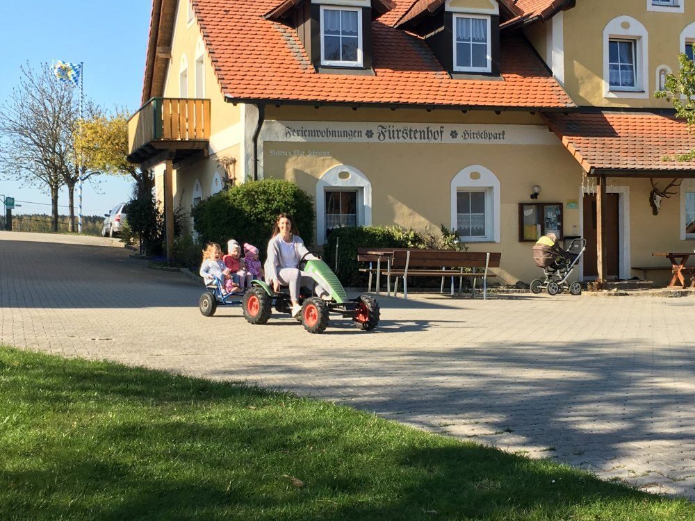 Kinder mit dem Tretbulldog vor dem Ferienhaus